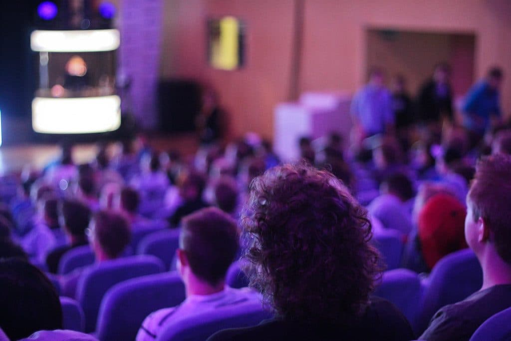 Crowd in a purple-lit esports arena